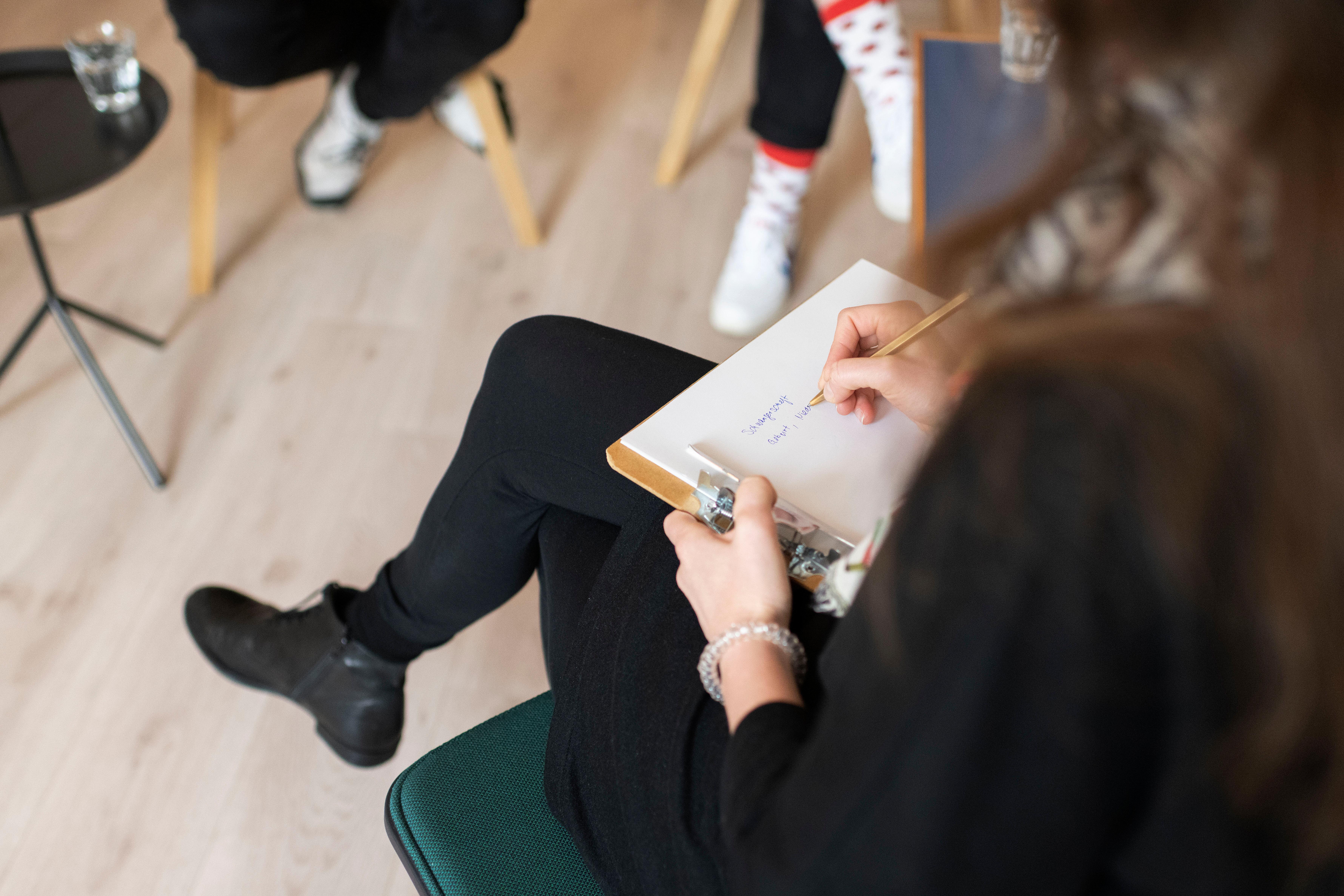 Gestellte Aufnahme: Eine Psychotherapeutin, rechts, therapiert einen Klienten und dessen Tochter im Teenageralter.