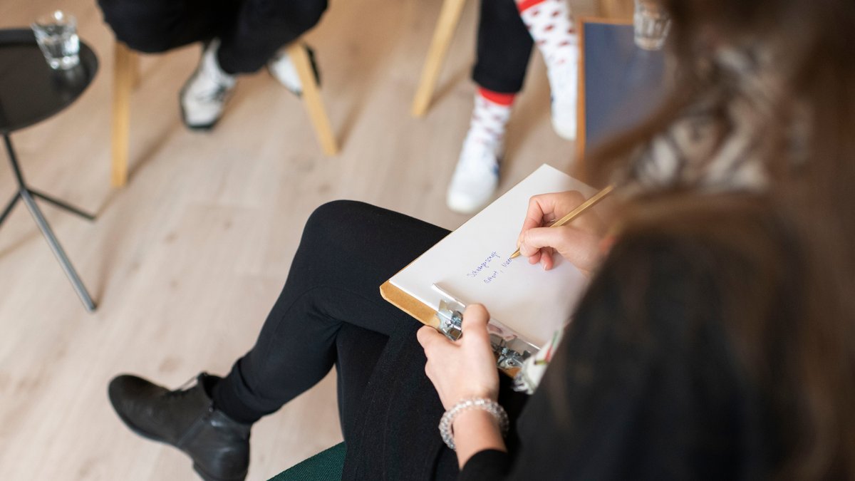 Gestellte Aufnahme: Eine Psychotherapeutin, rechts, therapiert einen Klienten und dessen Tochter im Teenageralter.