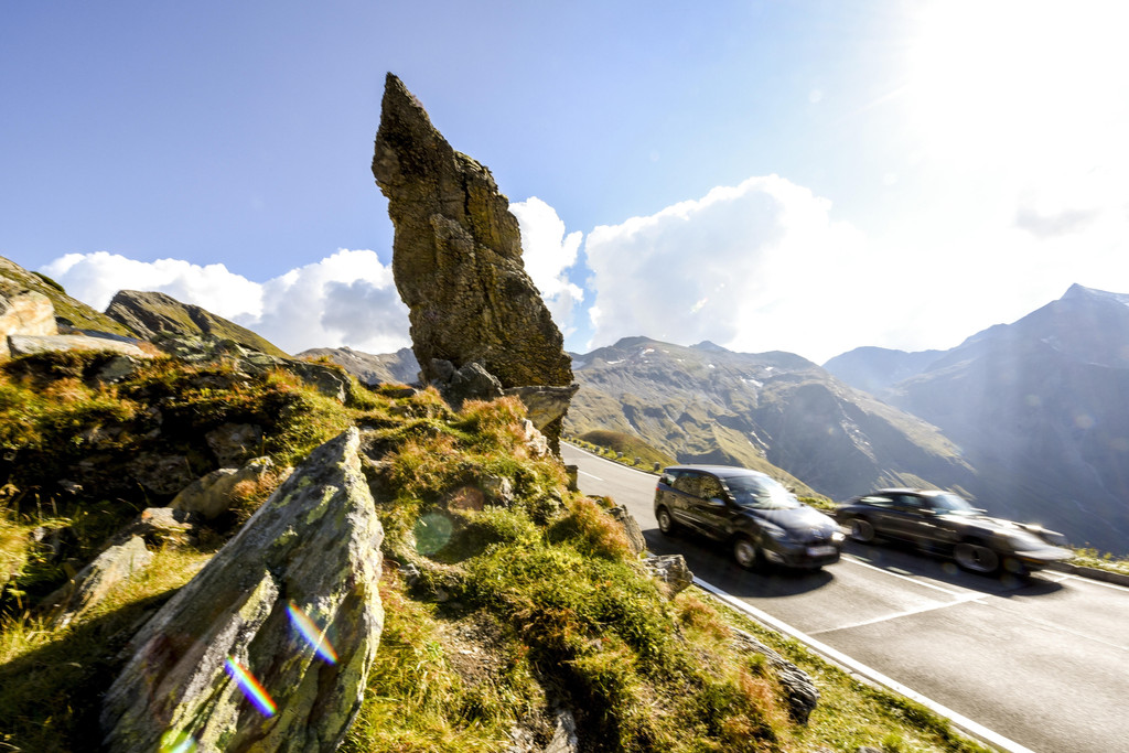 Autos in den Alpen: zwei schnelle Fahrzeuge beim Großglockner in Österreich. Straßenverkehr macht einen der größten Anteile beim CO2-Ausstoß aus.