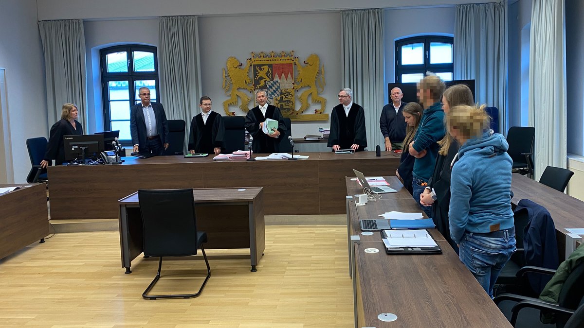 Die Angeklagten und ihre Verteidiger rechts im Vordergrund. Die Richter vor dem bayerischen Wappen im Hintergrund.