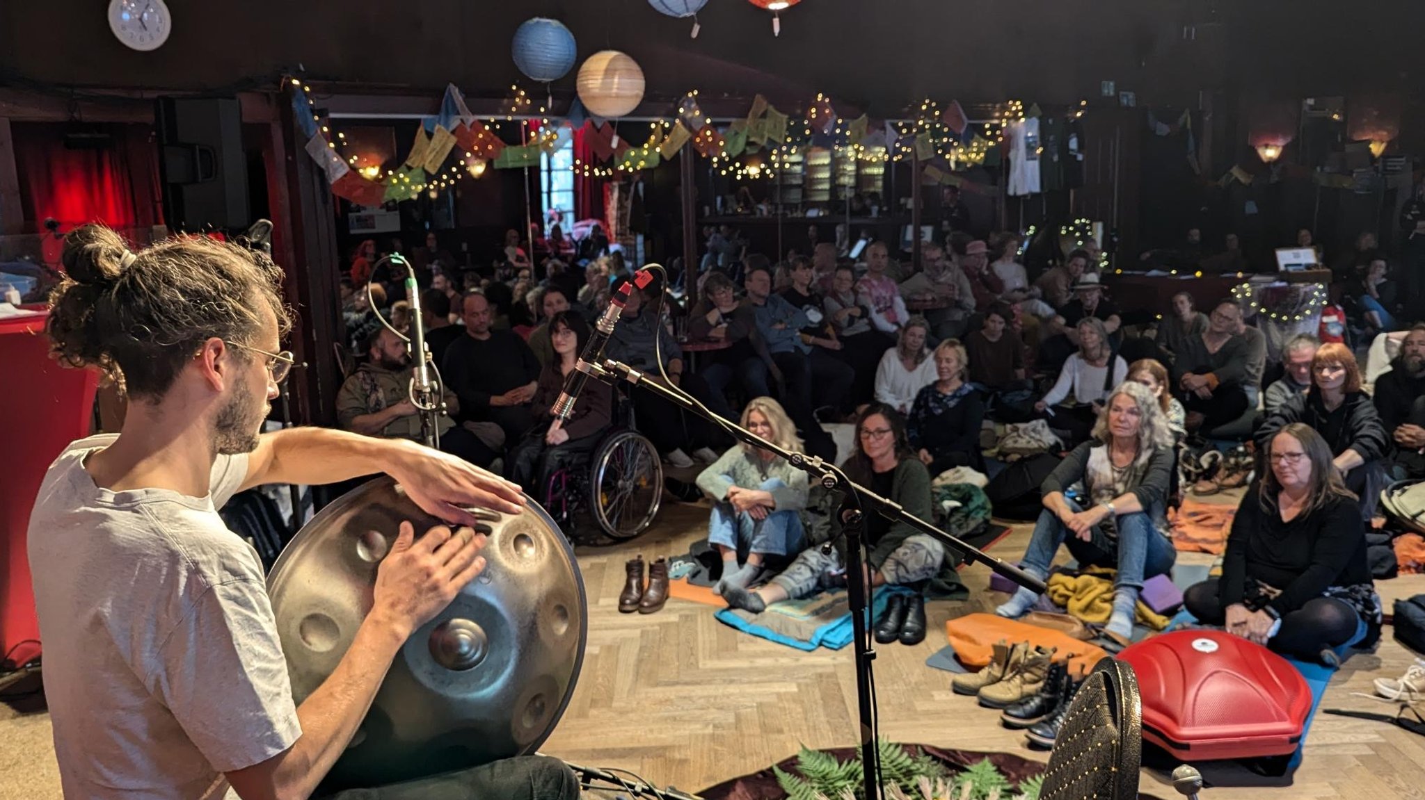 Ein Musiker spielt die Handpan vor Publikum. 