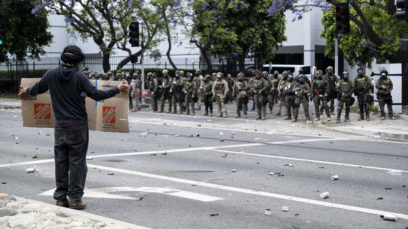 Ein Demonstrant steht den Sicherheitskräften gegenüber. Seit Tagen kommt es in Los Angeles zu Auseinandersetzungen. | Bild: picture alliance / Anadolu | Jon Putman Ein Demonstrant steht den Sicherheitskräften gegenüber. Seit Tagen kommt es in Los Angeles zu Auseinandersetzungen.