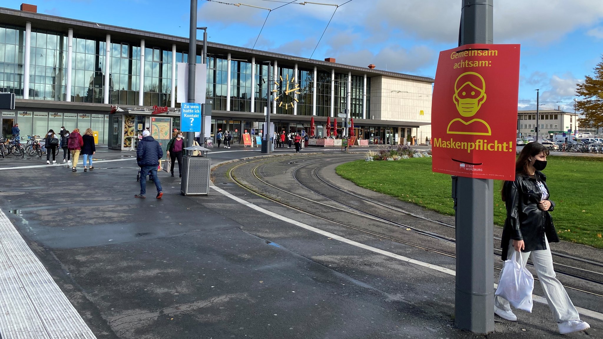 Auf dem Würzburger Bahnhofsvorplatz gilt eine Maskenpflicht. Schilder weisen darauf hin.