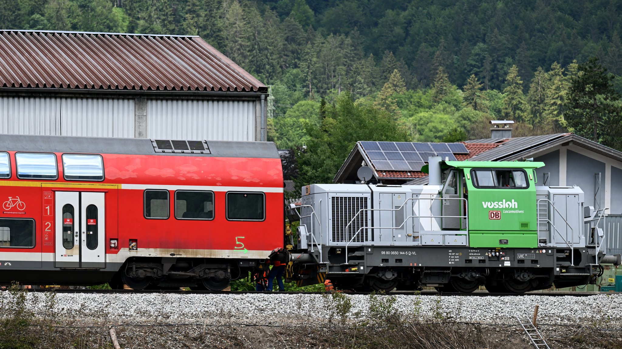 Ein Waggon vom verunfallten Regionalzug wird von einer Lok abtransportiert. Nach dem Zugunglück mit Toten und Verletzten wird die Bergung der letzten Zugteile mit einem speziellen Schienenkran durchgeführt.