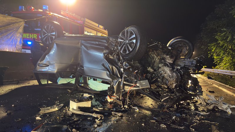 Ein völlig zerstörtes Autowrack liegt auf dem Dach. Im Hintergrund ist ein Feuerwehrfahrzeug zu sehen. | Bild: News5 Ein völlig zerstörtes Autowrack liegt auf dem Dach. Im Hintergrund ist ein Feuerwehrfahrzeug zu sehen.