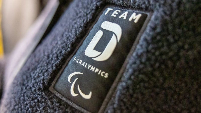 Detailaufnahme des Logos von Team Deutschland Paralympics auf einer Fleecejacke | Bild: picture alliance / Eibner-Pressefoto | Eibner-Pressefoto/Ardan Fuessman Detailaufnahme des Logos von Team Deutschland Paralympics auf einer Fleecejacke
