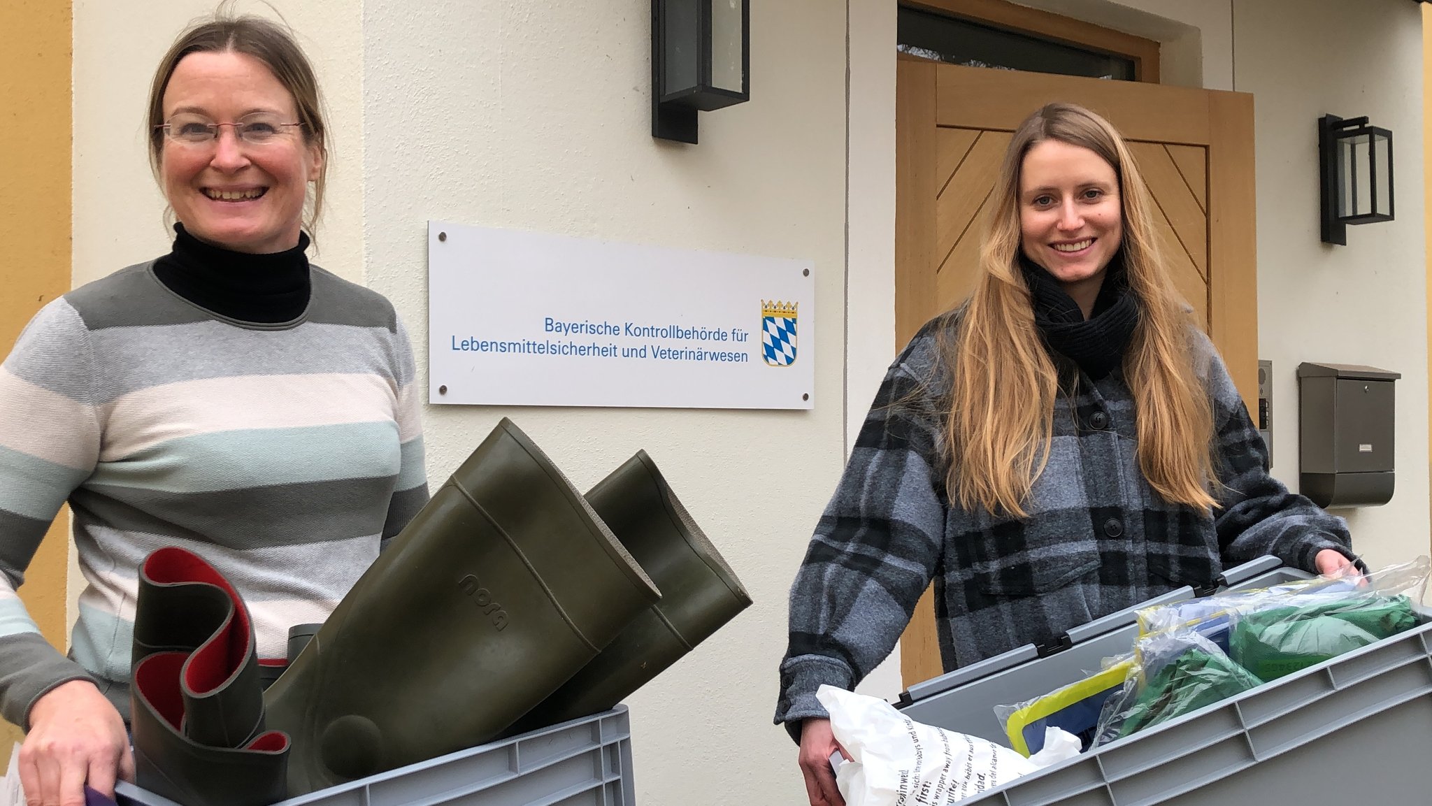 Tierärztin Isabel Baumgart und Juristin Anna Krumm mit zwei für eine Kontrolle voll bepackten Kisten.