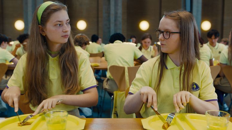 Zwei Internats-Schülerinnen beim Essen in der Mensa sehen sich kritisch an. | Bild:Neue Visionen Filmverleih