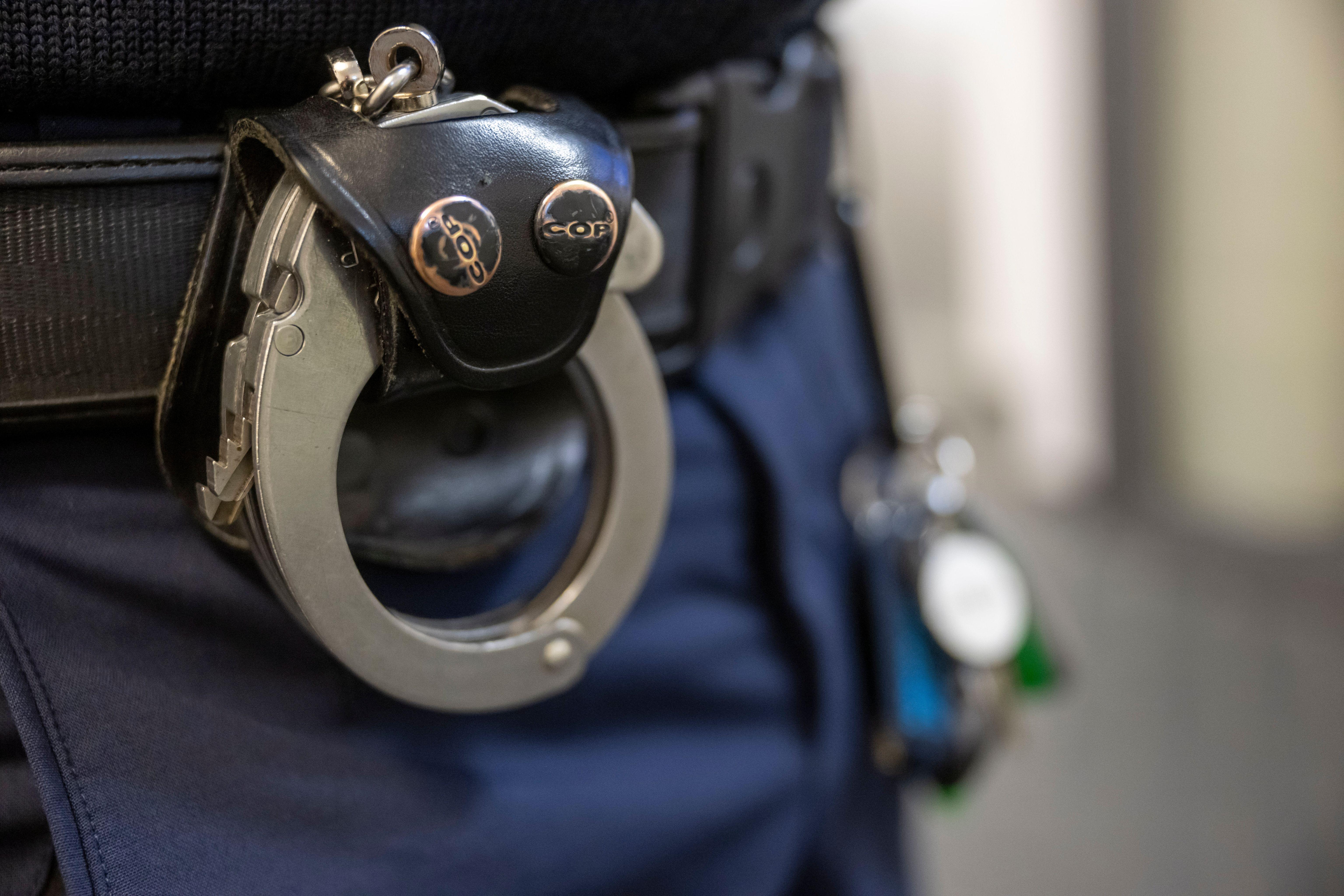 Symbolbild: Polizist mit Handschellen am Gürtel