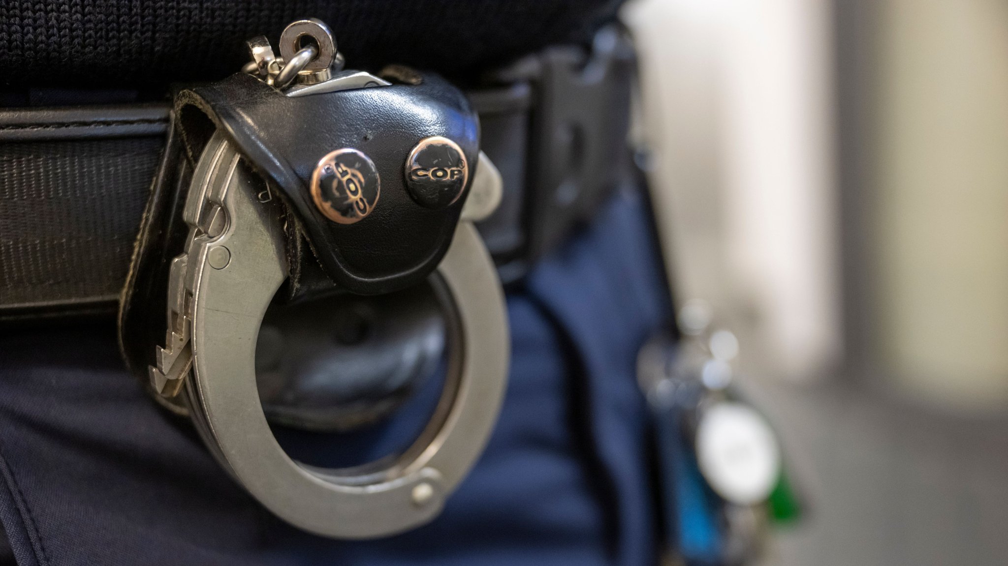 Symbolbild: Polizist mit Handschellen am Gürtel