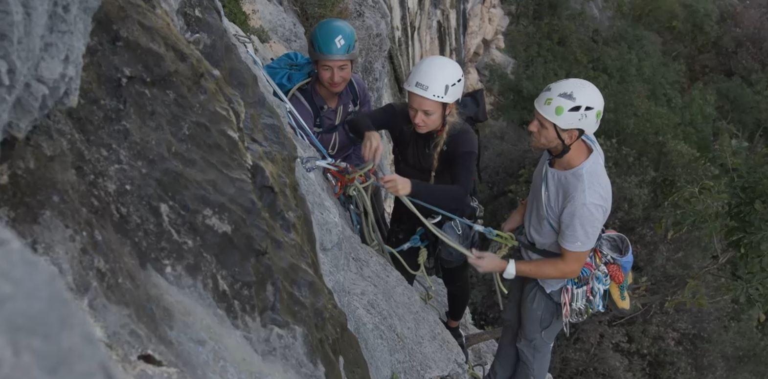 Bergführerin Monika Hümmer baut am Felsen mit zwei Teilnehmenden einen Standplatz im VDBS Evaluation Camp in Arco.