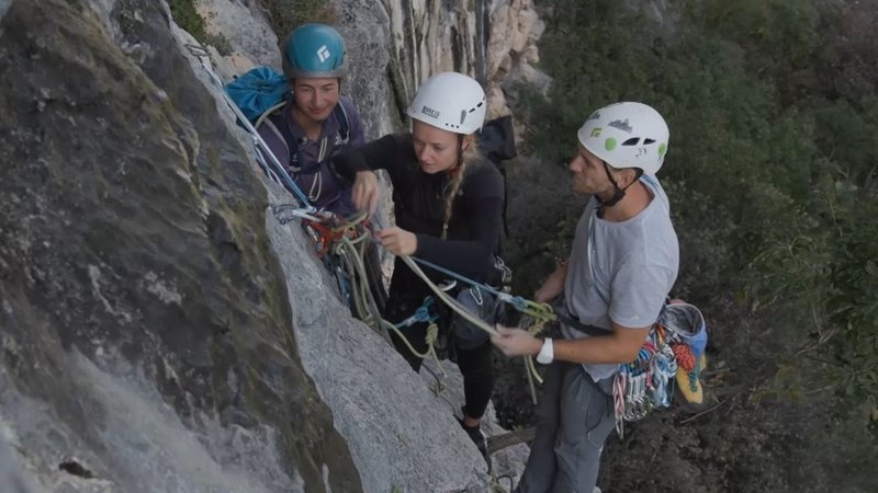 Bergführerin Monika Hümmer baut am Felsen mit zwei Teilnehmenden einen Standplatz im VDBS Evaluation Camp in Arco. | Bild: BR Bergführerin Monika Hümmer baut am Felsen mit zwei Teilnehmenden einen Standplatz im VDBS Evaluation Camp in Arco.