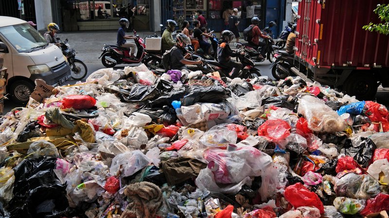 Indonesien, Jakarta: Autofahrer fahren am Straßenrand aufgetürmten Müll vorbei, der größtenteils aus Plastik besteht. | Bild: dpa-Bildfunk/Dita Alangkara Indonesien, Jakarta: Autofahrer fahren am Straßenrand aufgetürmten Müll vorbei, der größtenteils aus Plastik besteht.