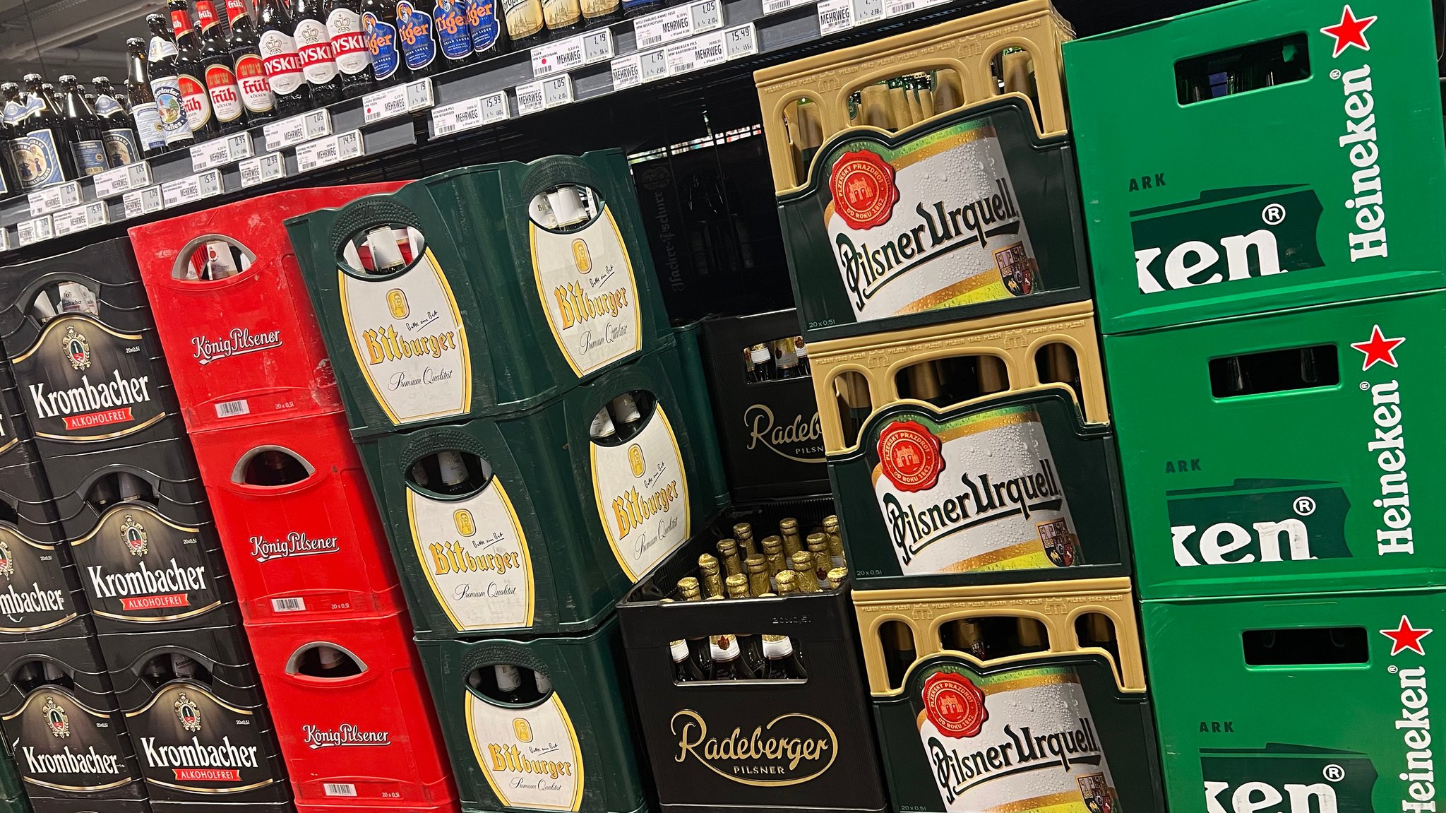 Gestapelte volle Bierkisten in einem Getränkemarkt.