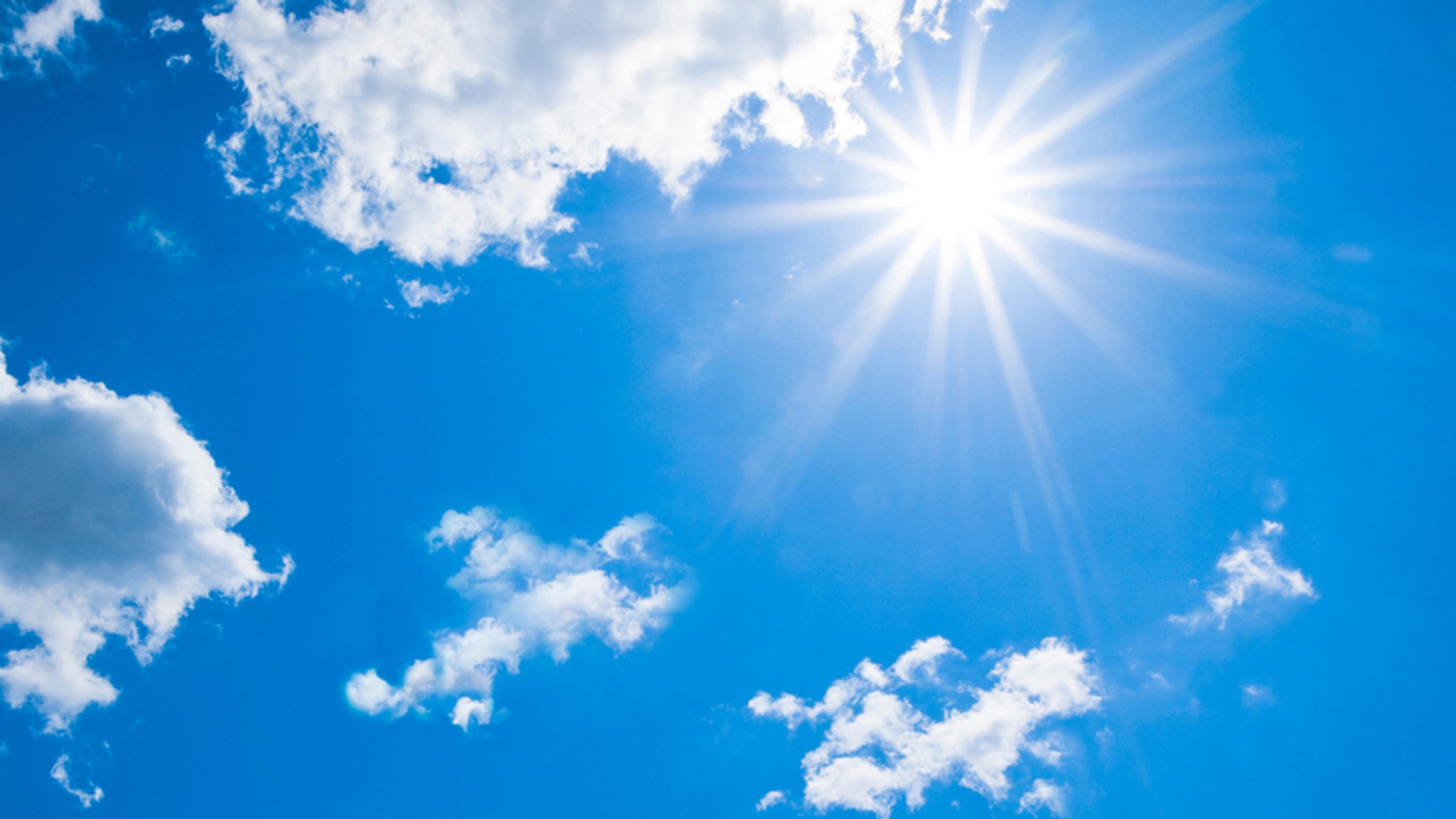 Blauer Himmel mit Sonne und Wolken (Symbolbild)