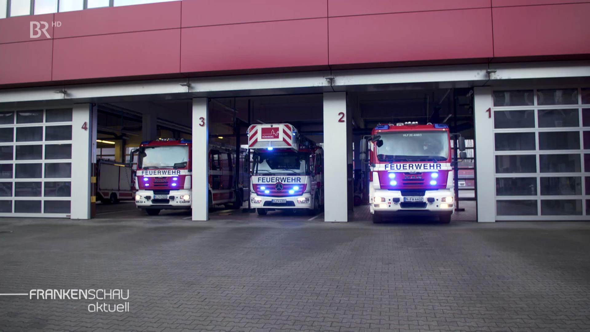 Drei Feuerwehrautos parken in einem Feuerwehrhaus.