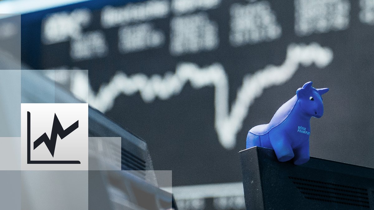 ein blauer Stier aus Gummi sitzt auf der oberen Kante eines Bildschirmes. Im Hintergrund die Kurstafel der Börse