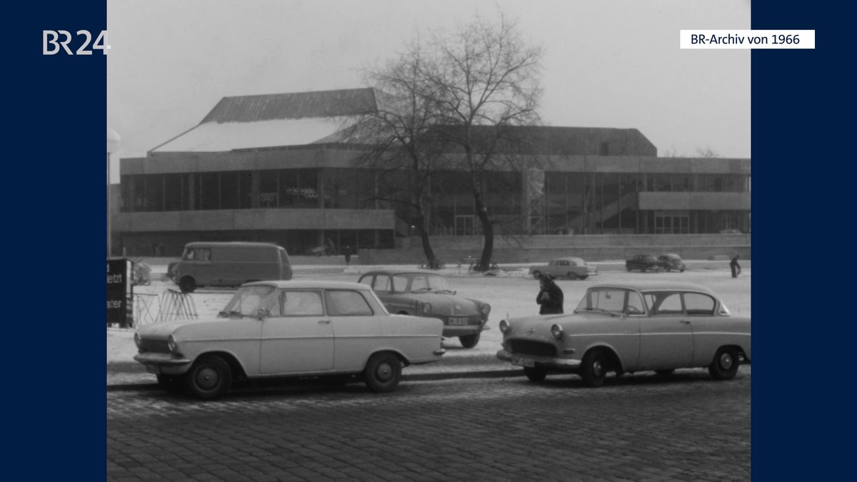 Stadttheater Ingolstadt hinter parkenden Autos.