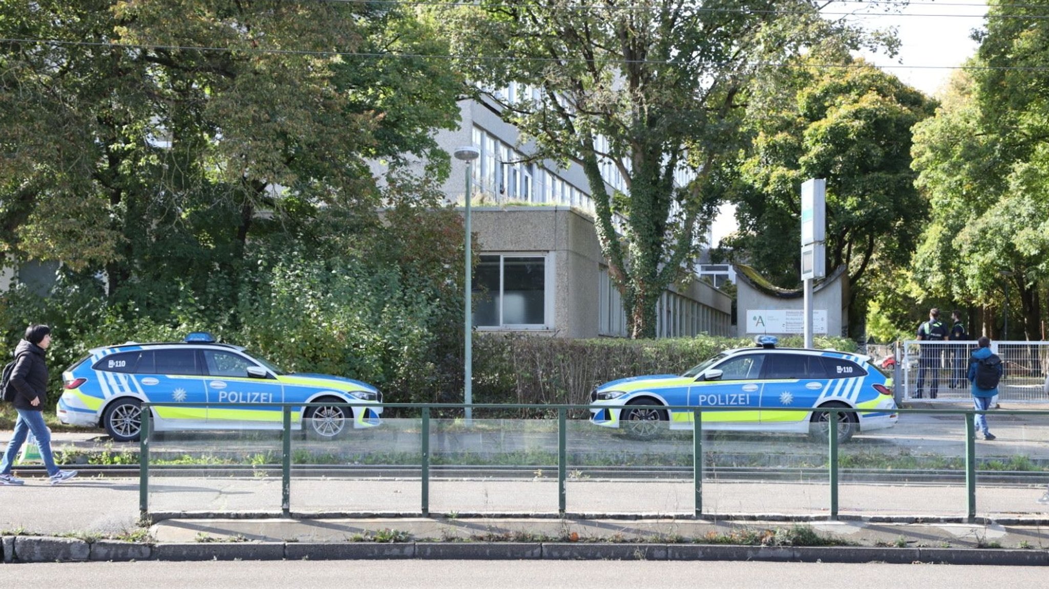 Zwei Polizeiautos vor der Berufsschule in Augsburg