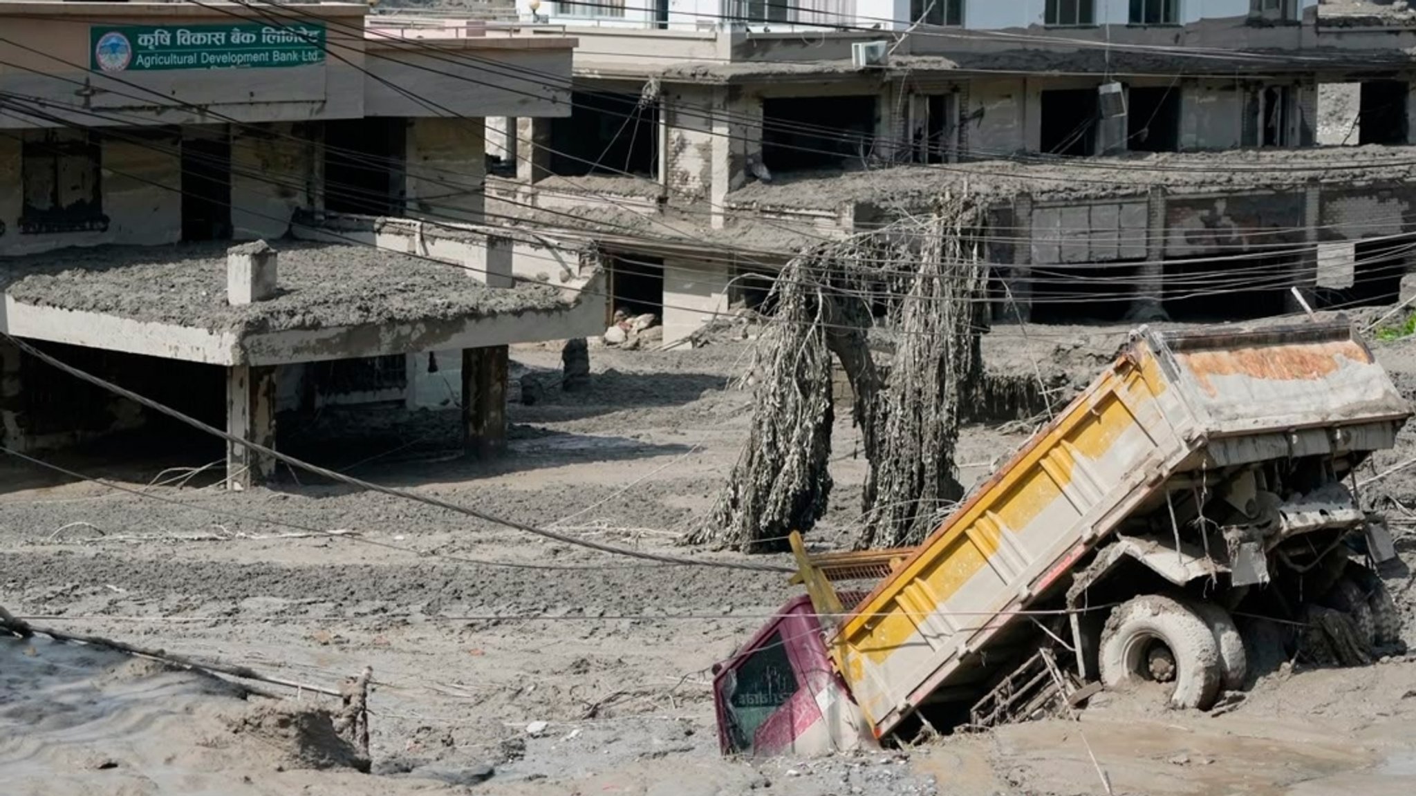 Nach den Sturzfluten entlang des Trishuli-Flusses im nepalesischen Distrikt Nuwakot sind beschädigte Häuser und Fahrzeuge zu sehen (26.08.2026). 