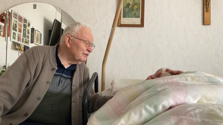 Wolfgang Hirschmann sitzt am Pflegebett seiner pflegebedürftigen Ehefrau Elise. | Bild:BR/Pirmin Breninek