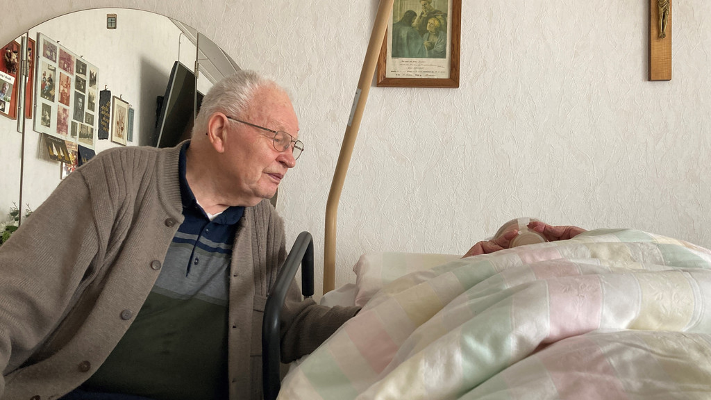 Wolfgang Hirschmann sitzt am Pflegebett seiner pflegebedürftigen Ehefrau Elise. | Bild: BR/Pirmin Breninek Wolfgang Hirschmann sitzt am Pflegebett seiner pflegebedürftigen Ehefrau Elise.