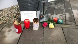 Blumen, Kerzen und ein Blatt Papier mit der Frage "Warum ???" vor dem Eingang des Tatort-Hauses in Mistelbach. | Bild:BR/Markus Feulner