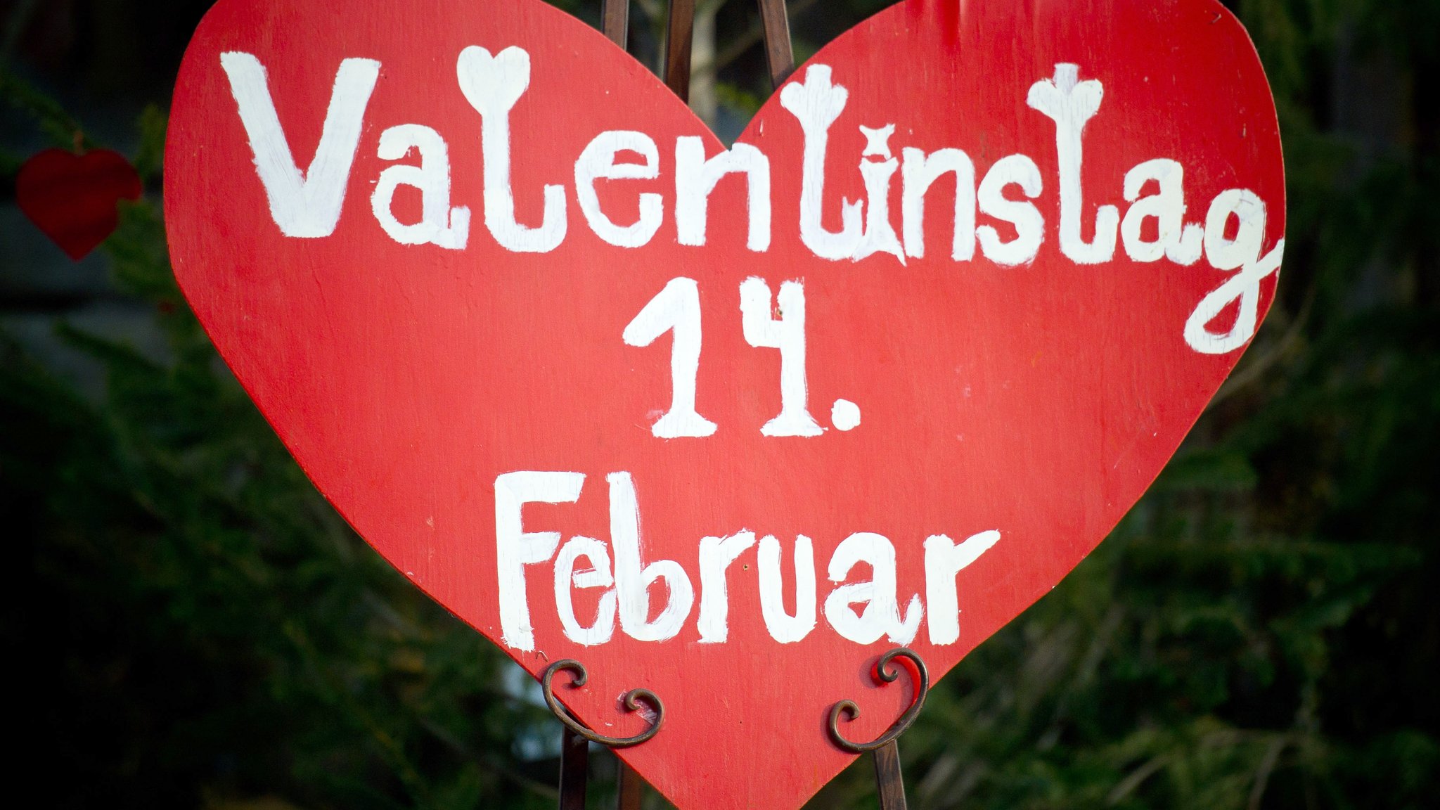 Vor einem Blumengeschäft steht ein großes Herz mit der Aufschrift "Valentinstag 14. Februar".