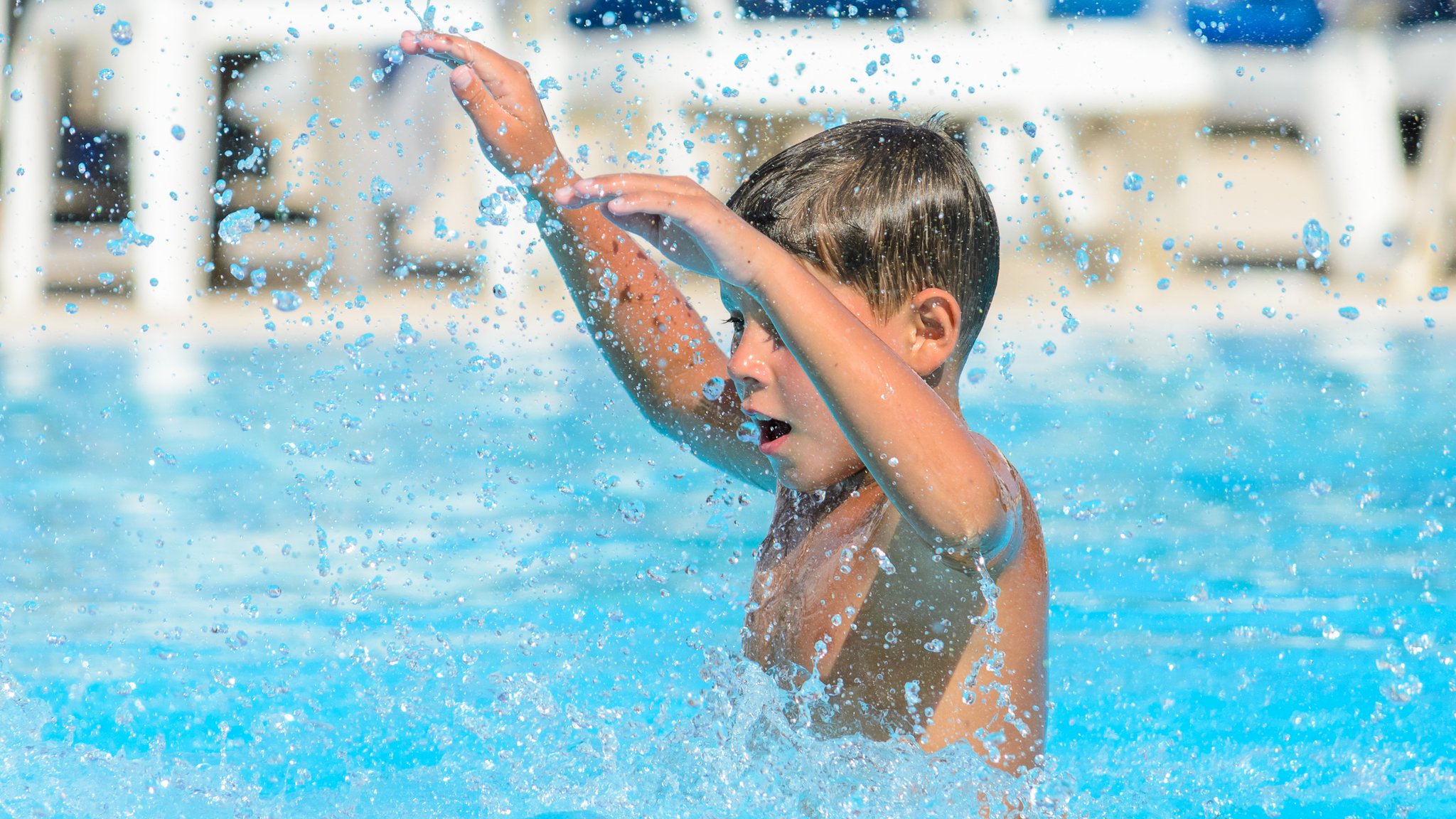 Ein Junge plantscht im Wasser