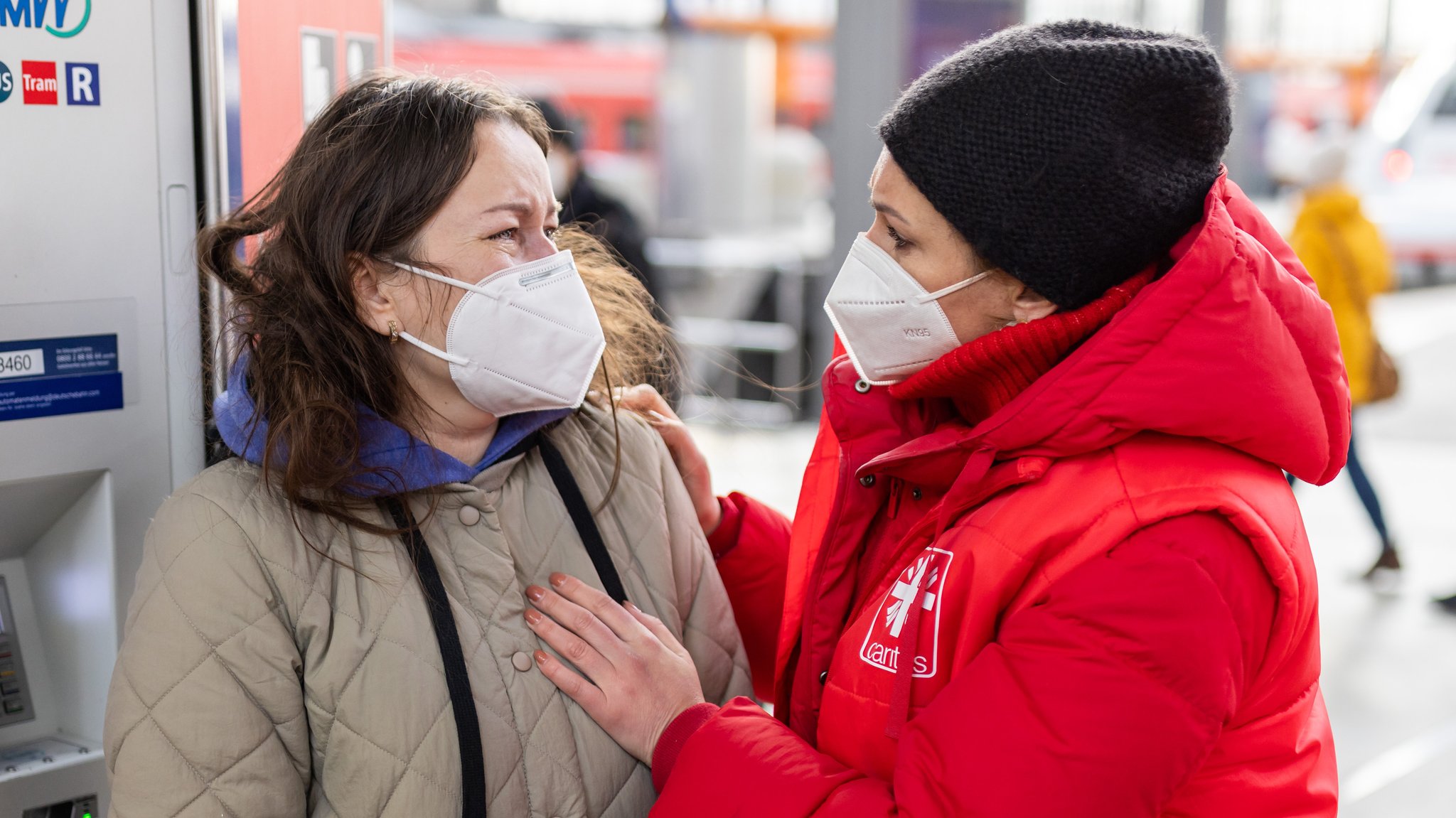 Anna (l), die mit ihren Kindern aus der ukrainischen Hauptstadt Kiew geflohen ist, wird nach ihrer Ankunft am Münchner Hauptbahnhof von einer Mitarbeiterin der Caritas betreut.