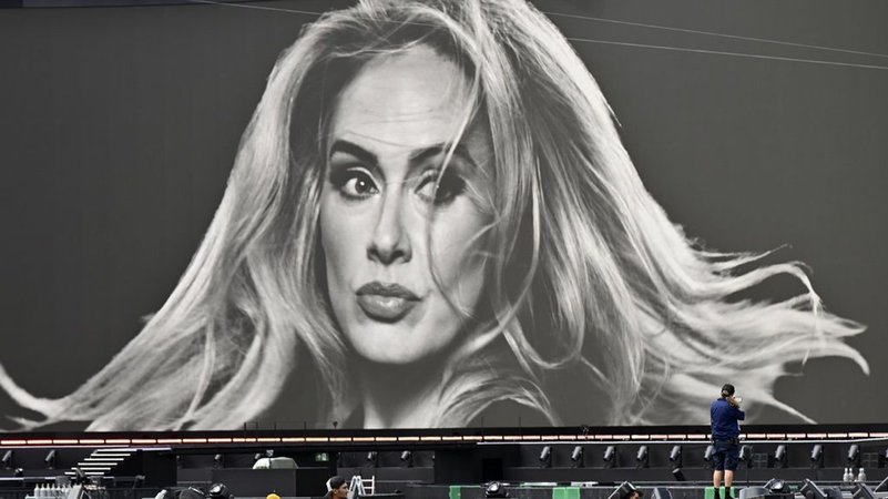 Ein Veranstaltungstechniker vor einer großen Leinwand mit einem Porträt der Sängerin Adele in der Adele World in München. | Bild: dpa-Bildfunk/Uwe Lein Ein Veranstaltungstechniker vor einer großen Leinwand mit einem Porträt der Sängerin Adele in der Adele World in München.