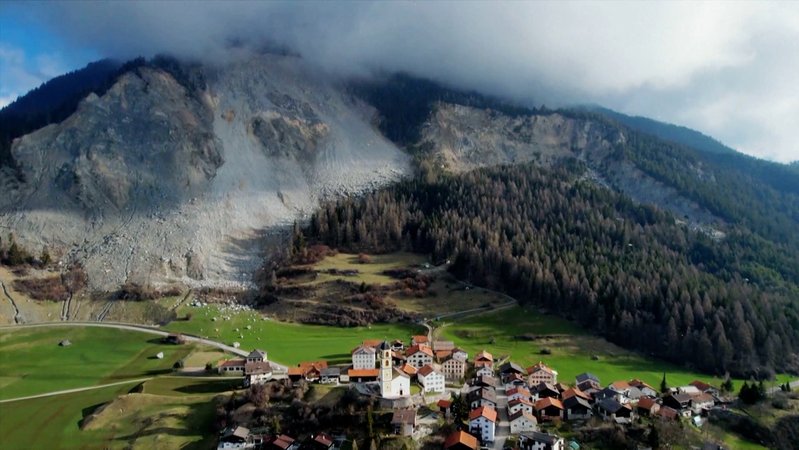  Herabgestürzte Steine und Felsteile (hinten,l) liegen vor dem Dorf. Das Bergdorf Brienz wird wegen des drohenden Felssturzes evakuiert.