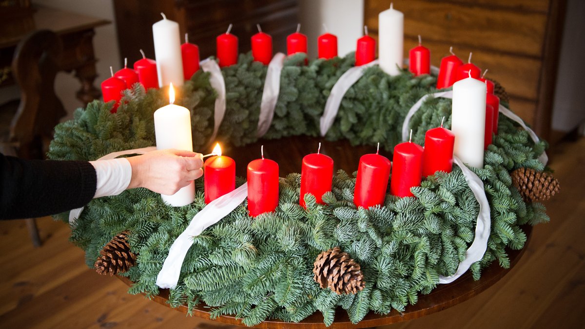Adventkranz aus Tannengrün mit roten Kerzen für die Werktage und weißen Kerzen für die Adventssonntage.