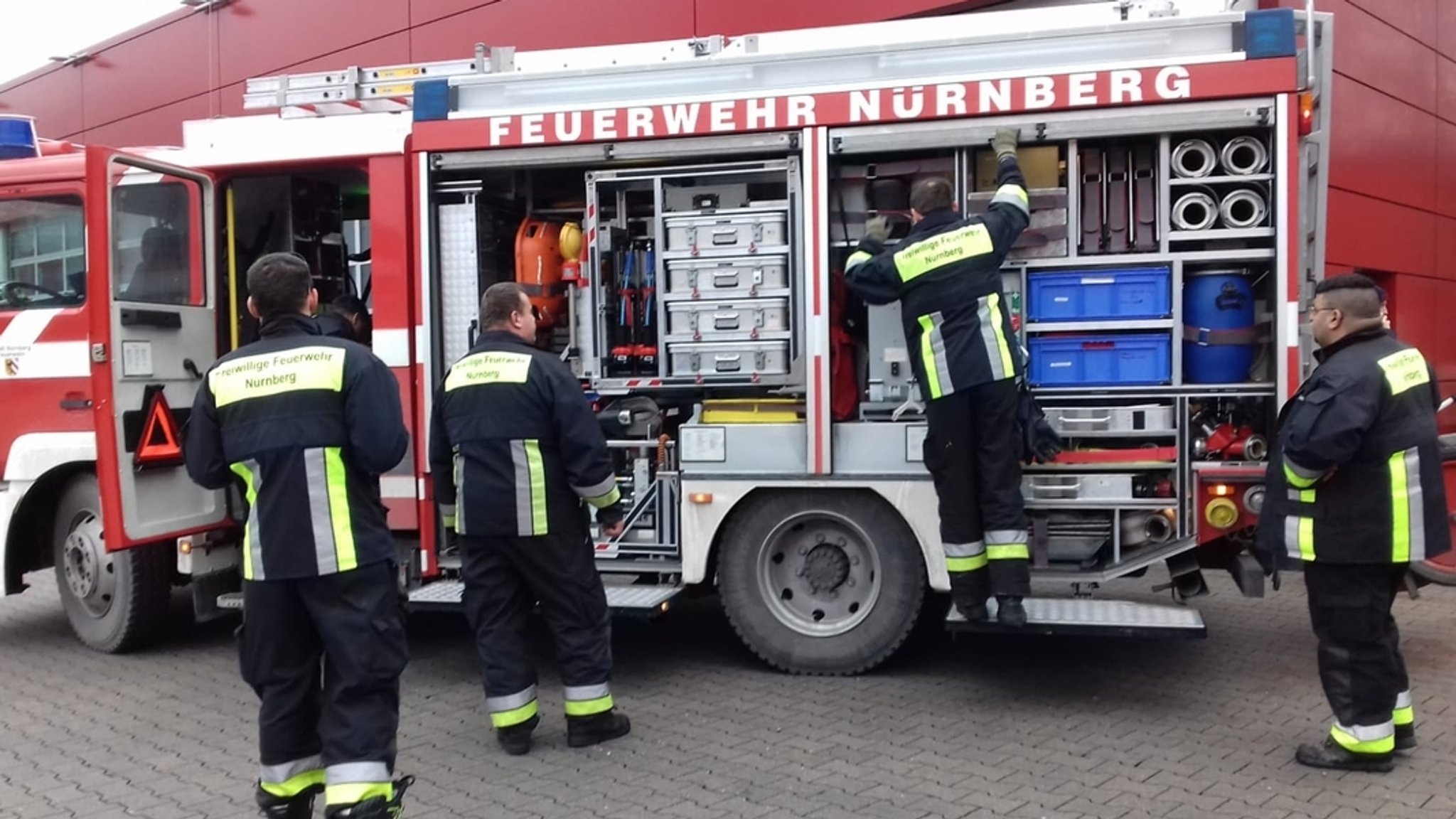 Feuerwehrmänner stehen vor einem Feuerwehrfahrzeug.