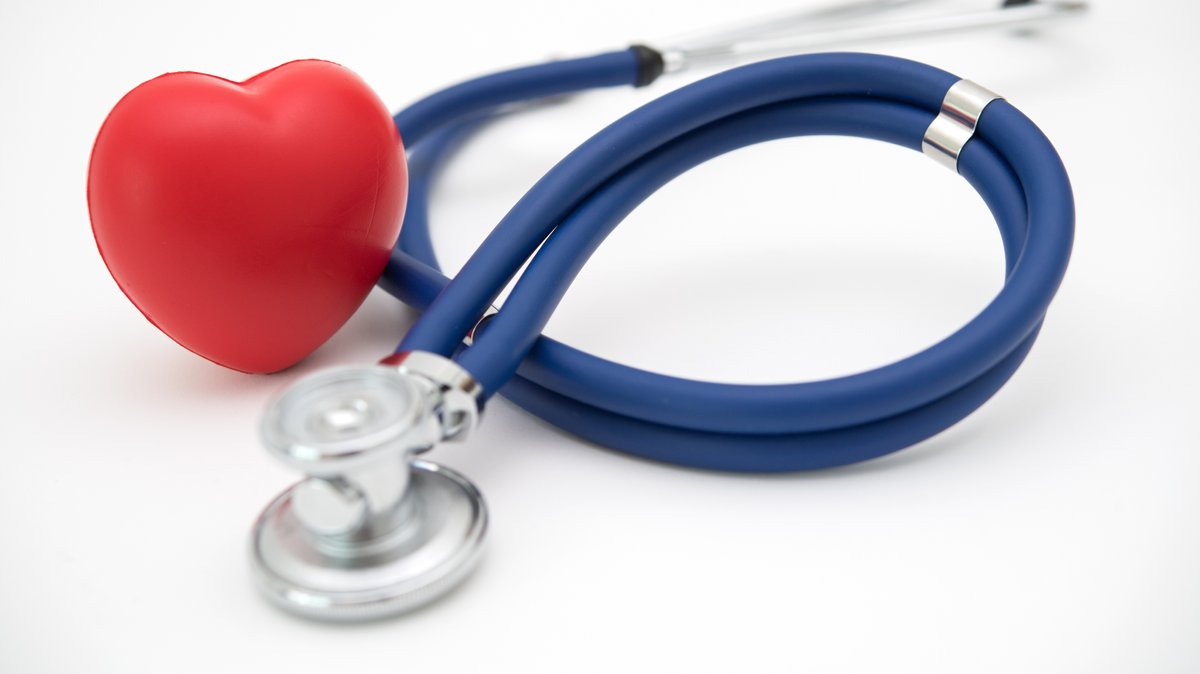 Ein Herz aus Kunststoff liegt neben einem Stethoskop