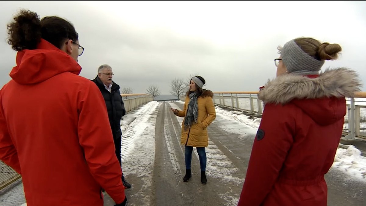 Menschen stehen im Winter auf einer Brücke über die A73 und diskutieren.