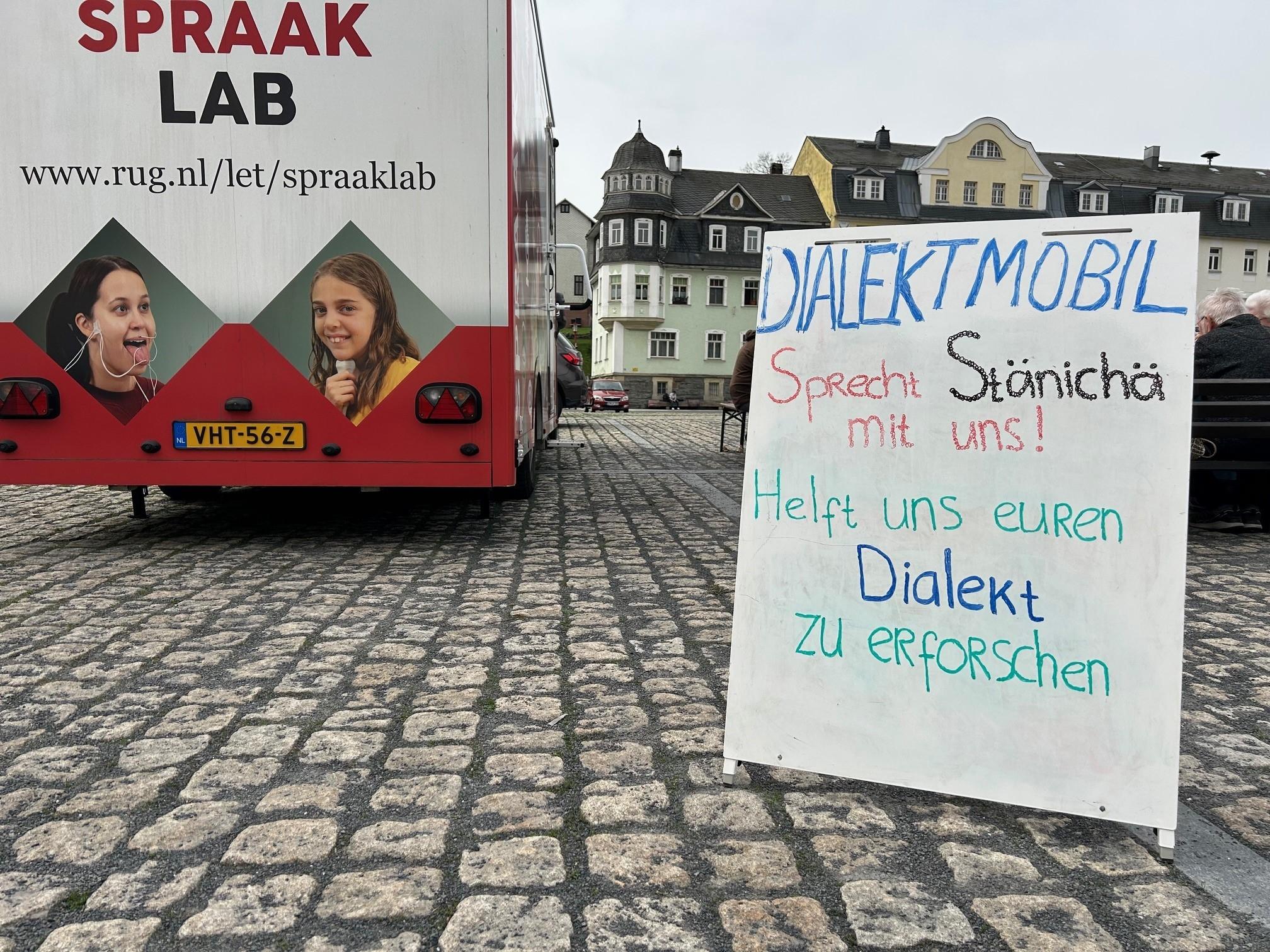Ein Schild vor einem mobilen Sprachlabor aus den Niederlanden fordert die Bürger im südthüringischen Steinach dazu auf, mit Wissenschaftlern Dialekt zu reden.