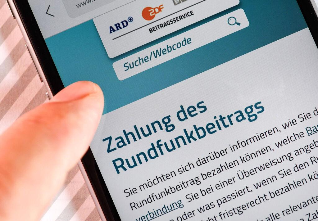 ARCHIV - 17.07.2018, Berlin: Auf einem Smartphone ist eine Website zur Information über die Zahlung des Rundfunkbeitrags aufgerufen. (zu dpa: «Kommission empfiehlt Erhöhung des Rundfunkbeitrags auf 18,94 Euro») Foto: Jens Kalaene/zb/dpa +++ dpa-Bildfunk +++