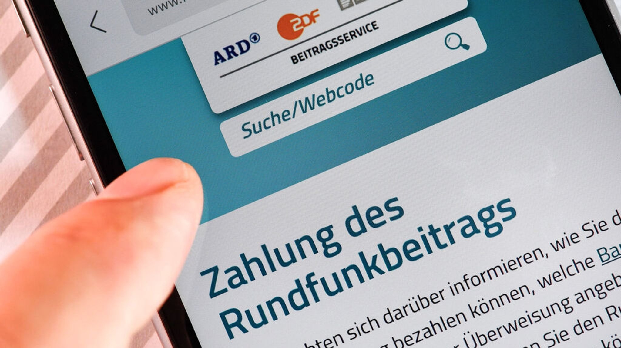 ARCHIV - 17.07.2018, Berlin: Auf einem Smartphone ist eine Website zur Information über die Zahlung des Rundfunkbeitrags aufgerufen. (zu dpa: «Kommission empfiehlt Erhöhung des Rundfunkbeitrags auf 18,94 Euro») Foto: Jens Kalaene/zb/dpa +++ dpa-Bildfunk +++