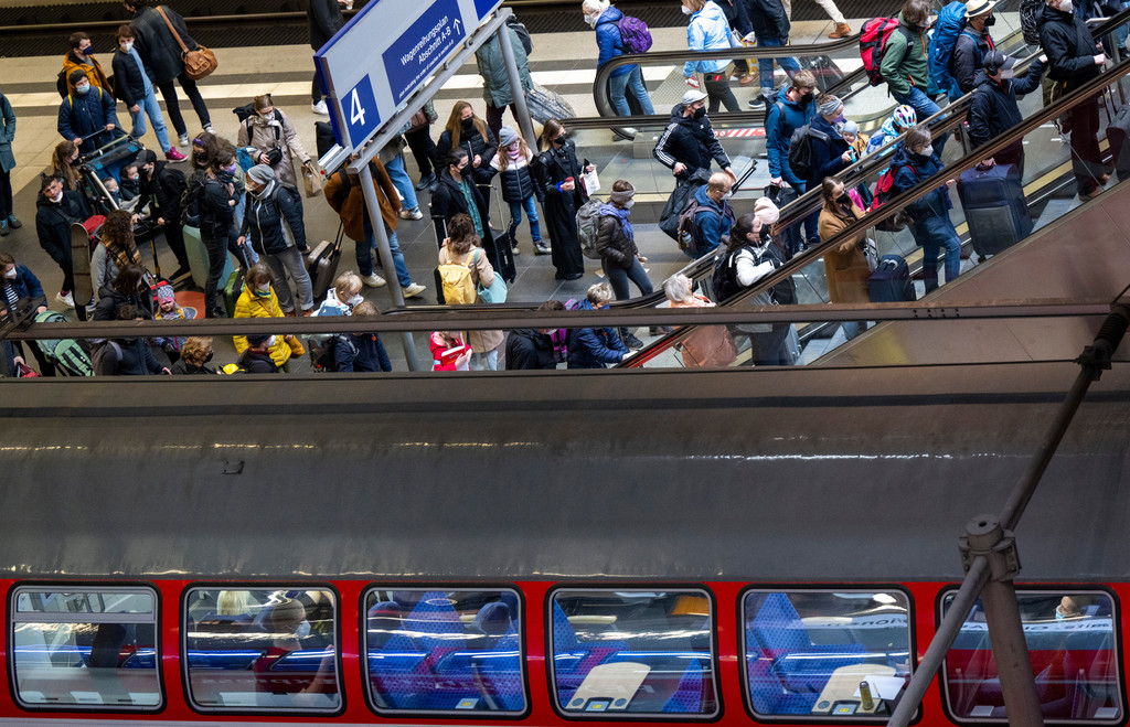 Zahlreiche Reisende steigen aus einem Regionalzug im Hauptbahnhof aus und fahren mit der Rolltreppe nach oben.