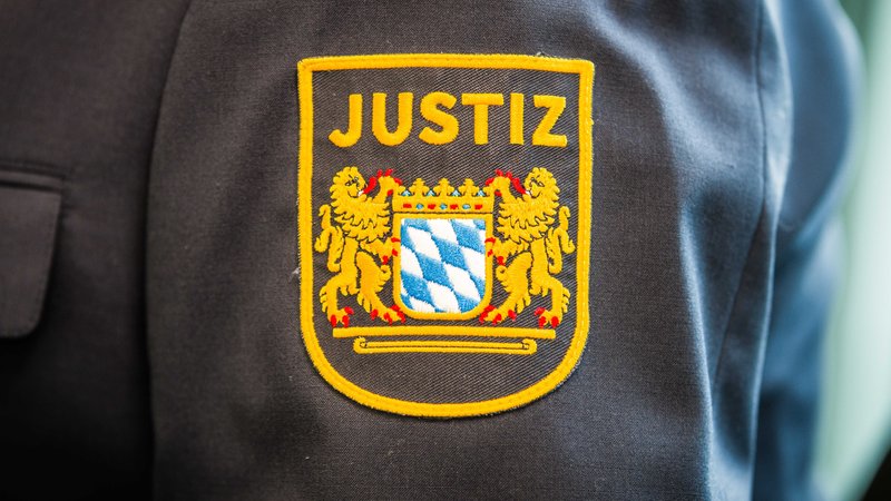 Symbolbild: Schriftzug "Justiz" mit Bayernwappen auf einem Ärmel.