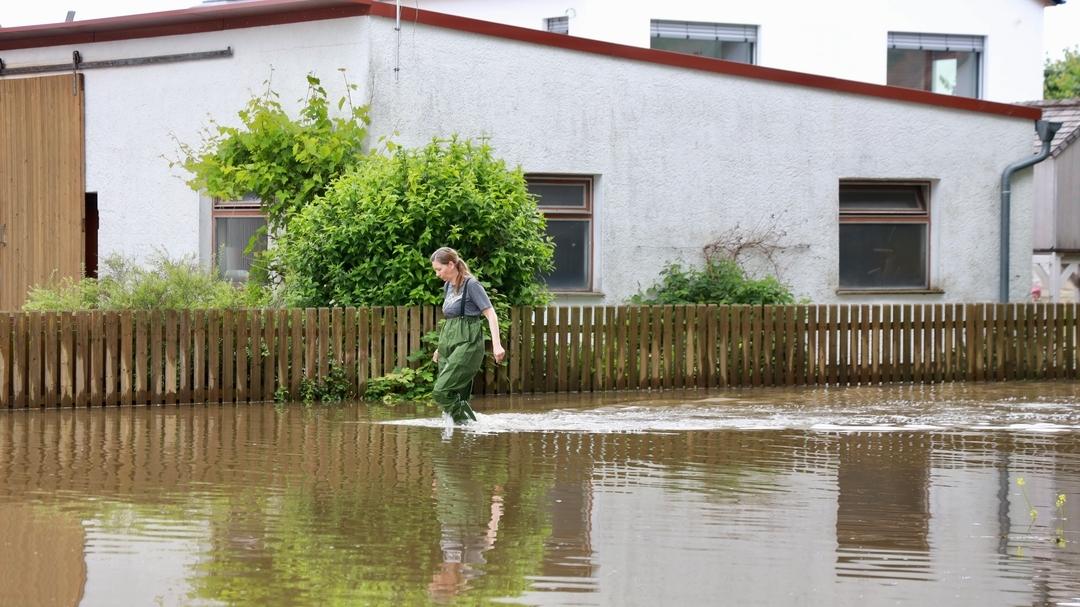 Eine Frau geht durch knietiefes Wasser.