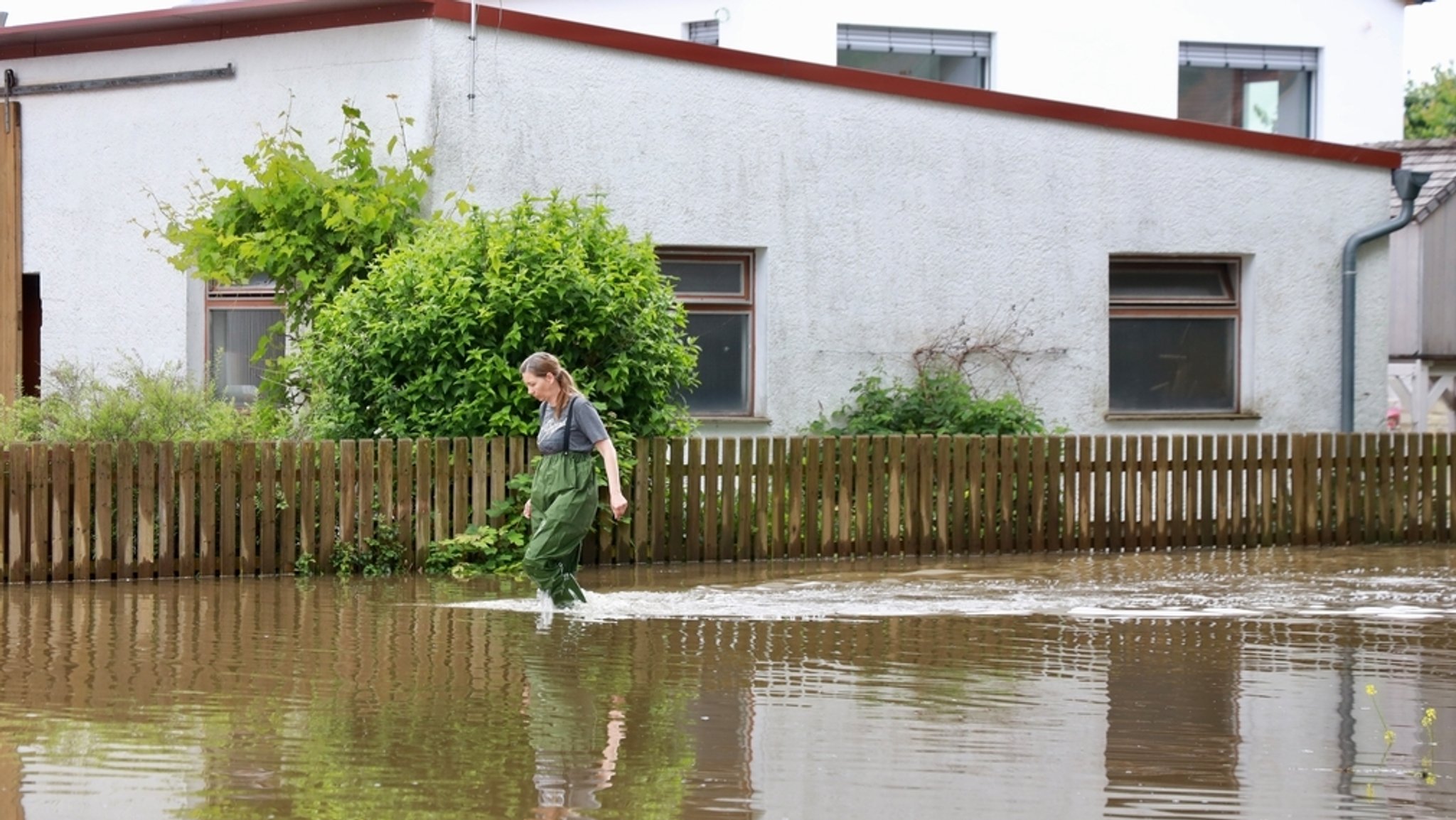 Eine Frau geht durch knietiefes Wasser.