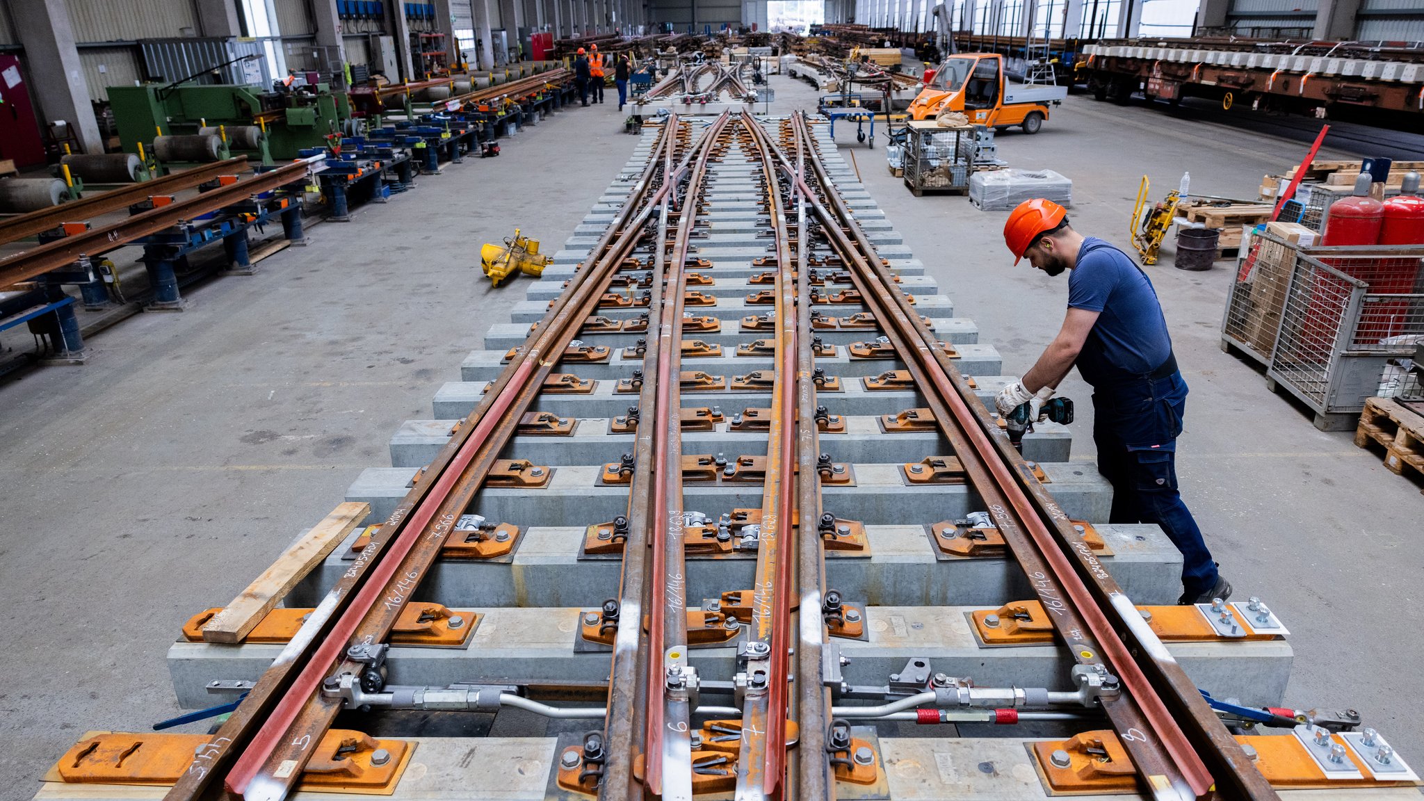 Arbeiter montieren im Werk Oberbaustoffe der Deutschen Bahn (DB Netze) doppelte Kreuzungsweichen (DKW) zusammen (Symbolbild)