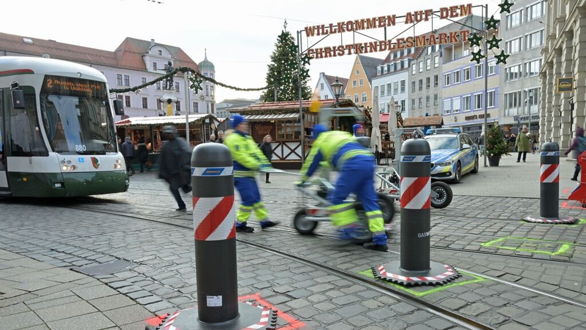 Arbeiter verschieben einen mobilen Poller, damit eine Trambahn durchfahren kann. | Bild: dpa-Bildfunk/Malin Wunderlich Arbeiter verschieben einen mobilen Poller, damit eine Trambahn durchfahren kann.