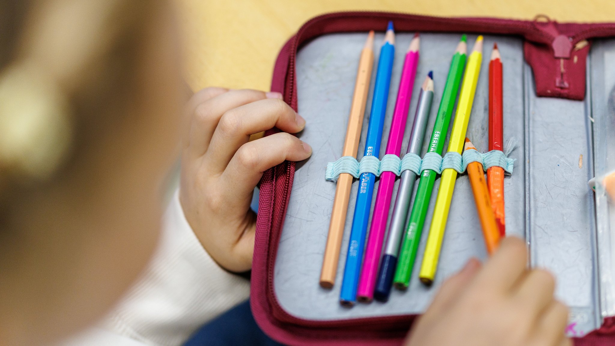 Ein kleines Mädchen nimmt einen Stift aus seinem Etui.