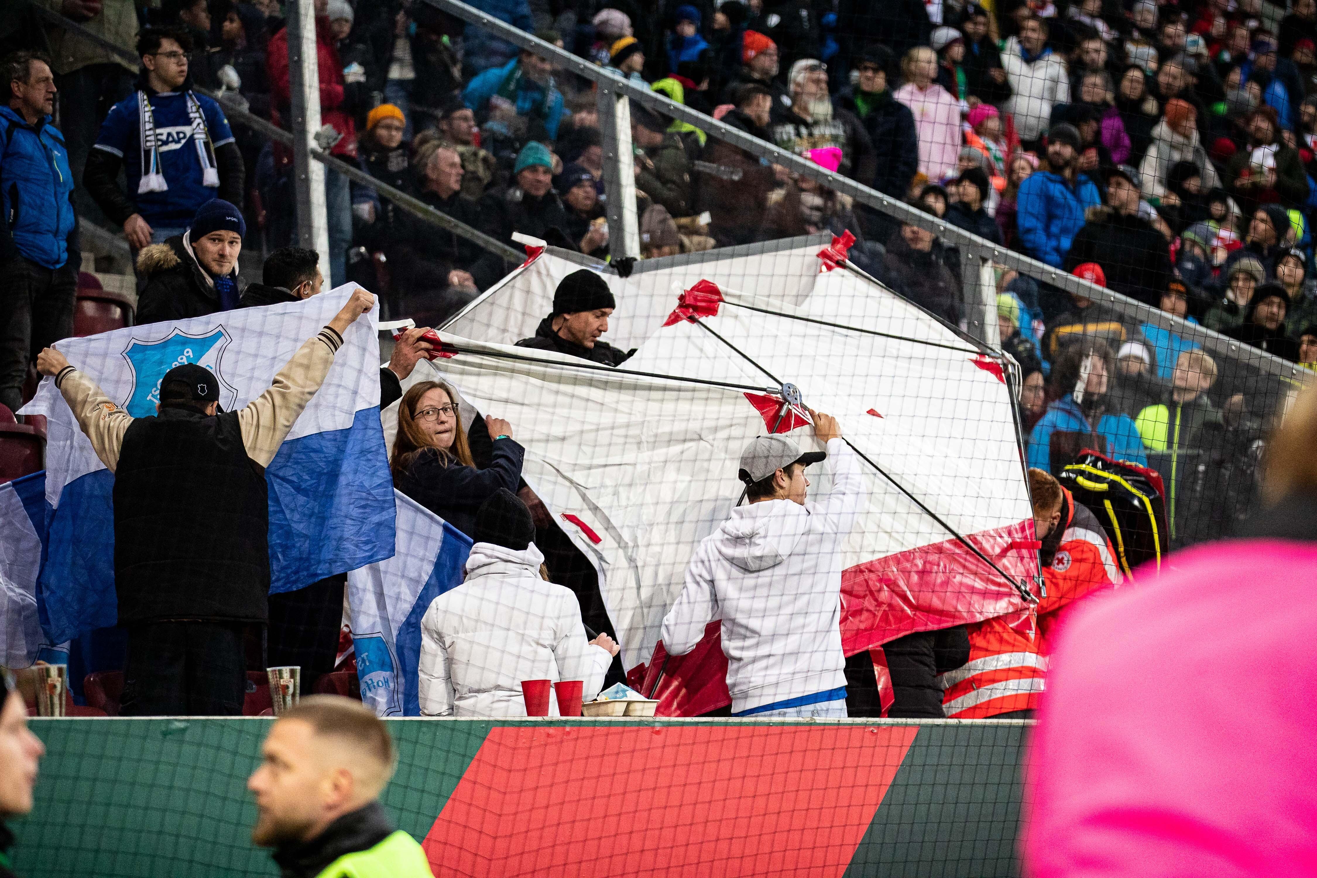 Nach einem Böllerwurf im Stadion des FC Augsburg werden verletzte abgeschirmt