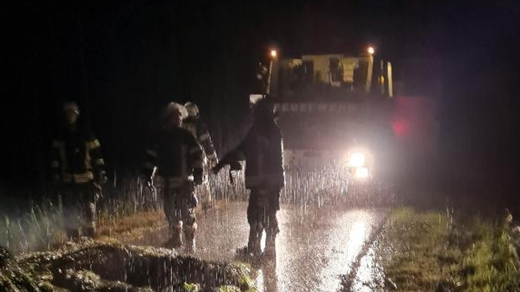 Einsatzkräfte der Feuerwehr im strömenden Regen im Kreis Passau