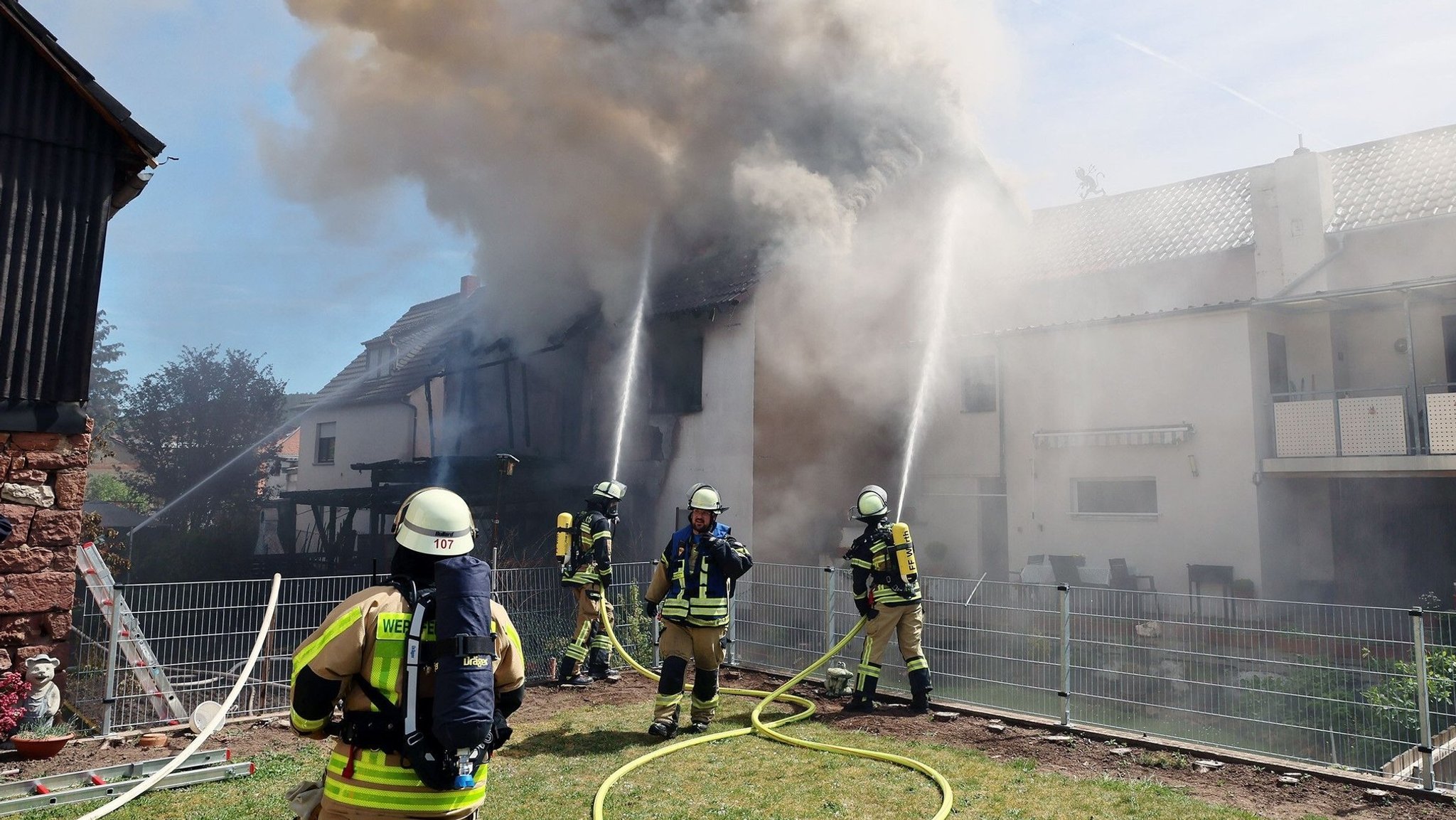 Feuerwehrleute löschen eine brennende Unterkunft für Geflüchtete in Wörth am Main. 