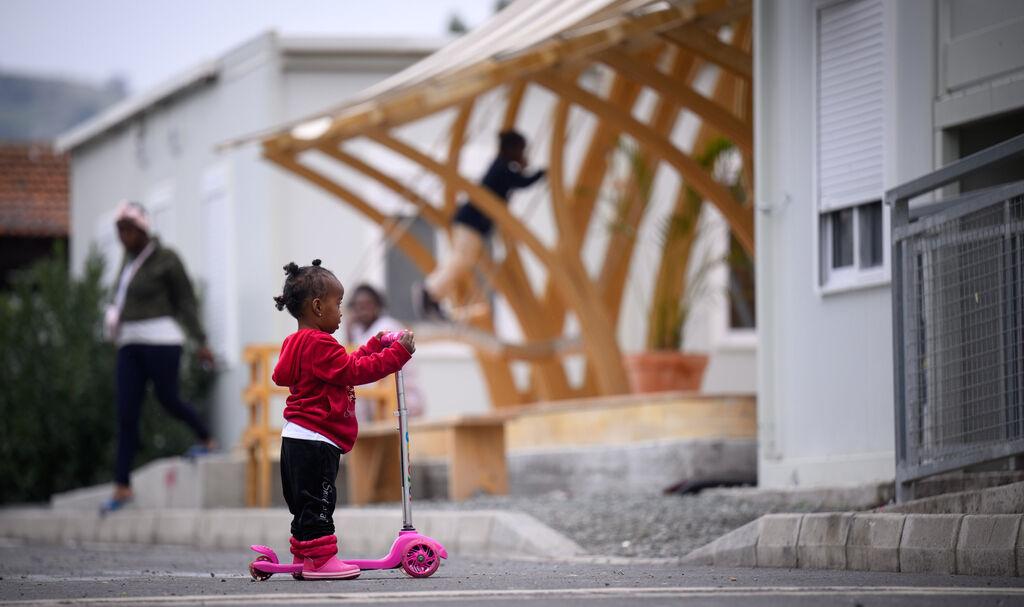 ARCHIV - 13.02.2024, Zypern, Kofinou: Ein kleines Flüchtlingskind steht auf einem Tretroller im Aufnahme- und Unterbringungszentrum für Asylbewerber in der Gemeinde Kofinou (Kofinou Reception and Accommodation Centre for Applicants for International Protection) vor Wohncontainern. Das Zentrum verfügt über 450 Betten zu Unterbringung von Flüchtlingen verschiedener Nationalitäten. (zu dpa: «Mehr als 100 Migranten auf Zypern binnen zwölf Stunden angekommen») Foto: Bernd von Jutrczenka/dpa +++ dpa-Bildfunk +++